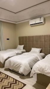 1 dormitorio con 2 camas y cabecero en فندق منيف بن طالب en Khamis Mushayt