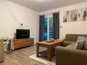 a living room with a couch and a television at Apartmani Braća Kovačević in Foča
