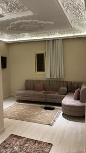 een woonkamer met een bank en een tafel bij فندق منيف بن طالب in Khamis Mushayt