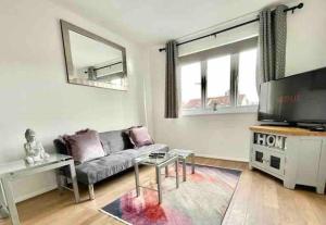 een woonkamer met een bank en een flatscreen-tv bij Modern Gem Apartment in Deptford with parking in Londen