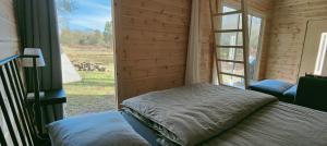 a bedroom with a bed in a room with a window at Tiny houses Liv & Lea in Listerby