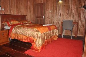 1 dormitorio con 1 cama grande y 1 silla en KSW BASE NAUTIQUE Isonalambo en Kribi