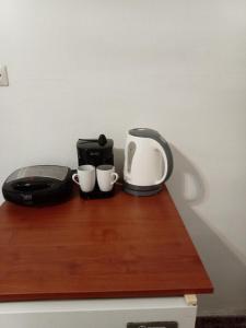 a coffee maker and two cups on a wooden shelf at Nikos Rooms pansion in Loutra Edipsou
