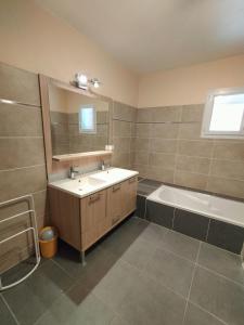 a bathroom with a sink and a tub and a mirror at villa Soleil 3chambres piscine in Lagorce