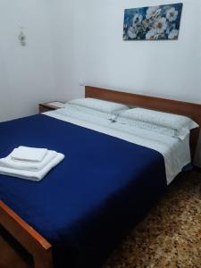 a blue bed in a room with a picture on the wall at Da Gianni in Pantelleria