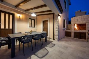 a dining room with a table and chairs and a fireplace at Villa Fran, Krk in Sveti Vid-Miholjice