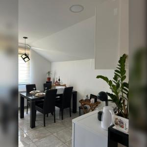 a kitchen and dining room with a table and chairs at Apartman Gold LUX in Surčin