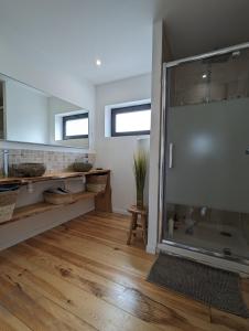 uma grande cabina de duche em vidro numa casa de banho com piso em madeira em Appartements du 101 em Villeneuve d'Ascq