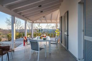 a table and chairs on a patio with a view at Due splendide e luminose ville recentemente ristrutturate! in SantʼAngelo in Pontano