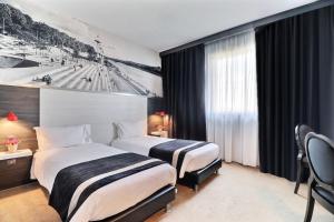Postel nebo postele na pokoji v ubytování Hôtel des Lumières Lyon Meyzieu Arena Stadium