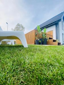ブワディスワボボにあるDomki Nord Breeze z podgrzewanym basenemの家の前の芝生の白いベンチ