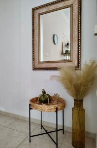 lustro i wiklinowy stół przed wazonem w obiekcie Tzitzifianaki Cozy Apartment w Chanii