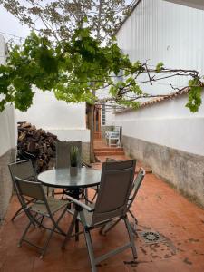 a patio with a table and chairs and a tree at Casa rural in Puebla de Don Fadrique