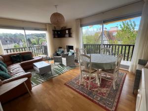 a living room with a table and chairs at La Vigie spacieux, lumineux, piscine in Deauville