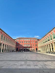 a large building with a courtyard in front of it at Diocletian wine studio apartment II in Split