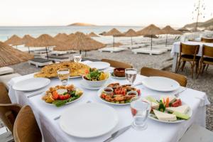 Yakaköy的住宿－Aylin Ahşap Evler，海滩上一张带食物盘的桌子