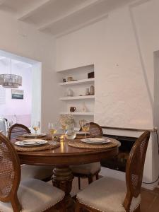 ein Esszimmer mit einem Holztisch mit Weingläsern in der Unterkunft Casa Barman Casco Antiguo Y Vistas Al Mar in Altea