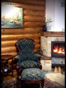 a chair in a living room with a fireplace at Cottage Lavanda окремий котедж з каміном in Bukovel