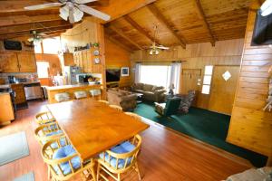 cocina y sala de estar con mesa de madera y sillas en Beautiful Lake Front home with gazebo - Johnson, en Bass Lake