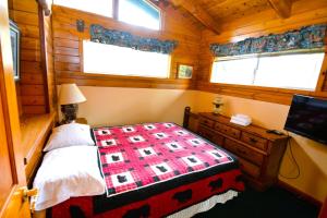1 dormitorio con 1 cama y TV en una cabaña en Beautiful Lake Front home with gazebo - Johnson, en Bass Lake