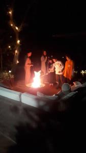 a group of people standing around a fire at night at Casa Nora Malinalco: entire estate w/pool 