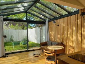 uma sala de estar com um jardim de Inverno com um telhado de vidro em Le mazet des amants, cabane en bois avec jacuzzi privatif em Avignon