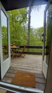 an open door to a deck with a picnic table at Maison Tronchiennes in Durbuy