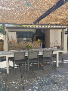 una mesa y sillas en un patio en Grande villa avec piscine et clim proche de la mer, en Marsillargues