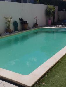 una gran piscina azul en un patio con plantas en Grande villa avec piscine et clim proche de la mer, en Marsillargues