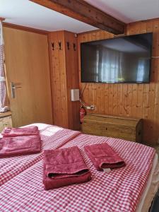 een slaapkamer met een bed met twee rode handdoeken erop bij Holiday Apartment in Swiss Alps in Gsteigwiler