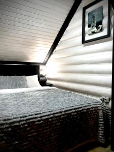 um quarto com uma cama com uma parede branca em Cottage Lavanda окремий котедж з каміном em Bukovel