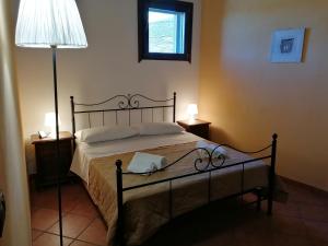una camera da letto con un letto con una lampada e una borsa bianca sopra di Nero Etna a Bronte