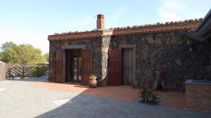 un edificio in pietra con una grande porta e un patio di Nero Etna a Bronte