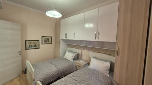 a small room with two beds and a cabinet at Aurora appartment in Tirana