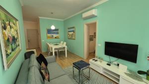 a living room with a couch and a flat screen tv at Aurora appartment in Tirana
