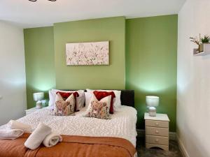sypialnia z zielonymi ścianami i łóżkiem z poduszkami w obiekcie Fabulous and Relaxing Holiday Sand Beach and Sun w Bournemouth