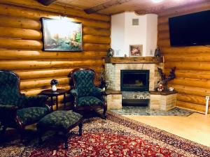 a living room with two chairs and a fireplace at Cottage Lavanda окремий котедж з каміном in Bukovel