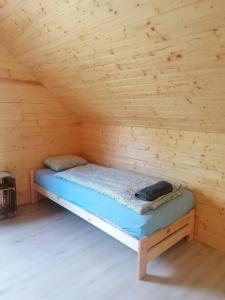 a bed in a wooden room in a cabin at Lisi Zakątek in Czarna