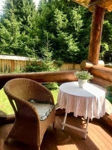 mesa y 2 sillas en un porche con mesa en Cottage Lavanda окремий котедж з каміном, en Bukovel