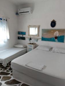 a bedroom with two beds and a painting on the wall at Summer House in Porto Heli +32 photos