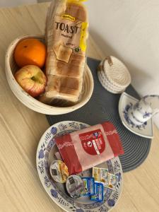 una mesa con un tazón de pan y un tazón de fruta en Freya´s room, en Česká Kamenice