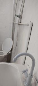 baño con aseo y tuberías en la pared en Suíte 2 beliches, cozinha e quintal compartilhados, en São Sebastião