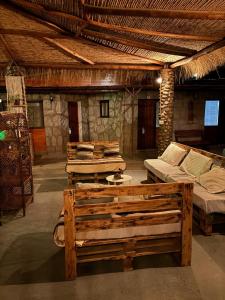 a room with several beds and a couch in it at Hostal Katarpe in San Pedro de Atacama