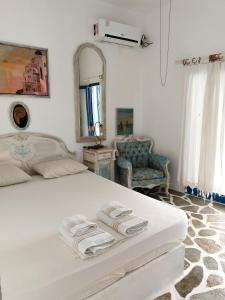 a bedroom with a white bed with towels on it at Summer House in Porto Heli