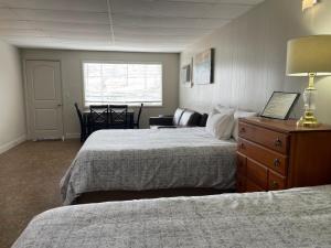 a hotel room with two beds and a dresser at Sunset Beach Resort in Osage Beach