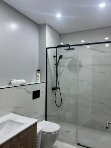 a bathroom with a shower and a toilet and a sink at Seventy in Póvoa de Varzim
