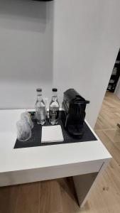 Una mesa blanca con dos botellas de agua y una bolsa. en BB Incentro Trani, en Trani