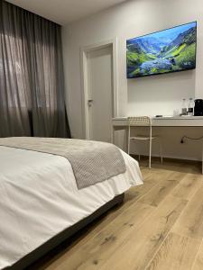 Un dormitorio con cama, escritorio y televisión. en BB Incentro Trani, en Trani