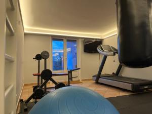 une salle de sport avec un tapis de course et une télévision dans l'établissement Lidingö, à Lidingö