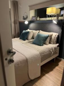 una camera da letto con un grande letto con cuscini blu di Boende med hotellkänsla i populära Skrea, Falkenberg a Falkenberg